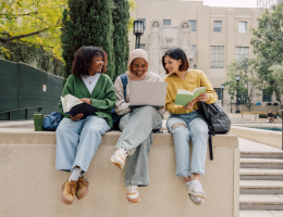 three young adults reading books outside