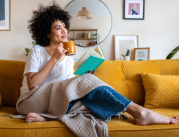 a young woman holding a coffee cup on the couch