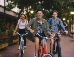three young adults riding bicycles