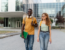 two students walking outside of an academic building