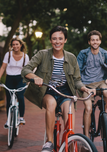 three young adults riding bicycles