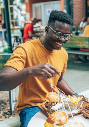 a man eating a hamburger outside